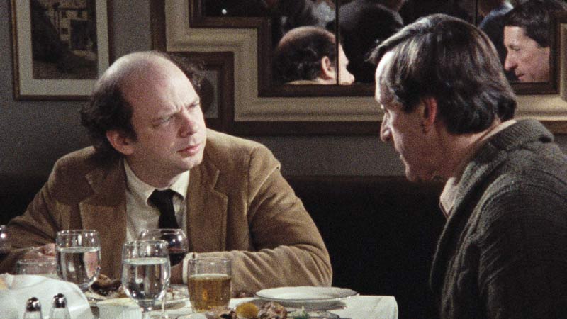 Das Bild zeigt zwei Männer im Gespräch an einem Tisch. Es ist ein Filmstill aus "Mein Essen mit André" von Louis Malle.